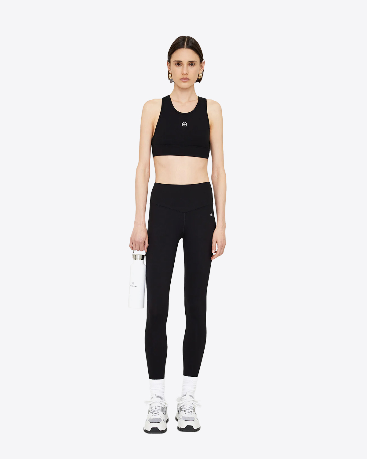 Legging stretch en polyamide et élasthanne noir mini logo AB devant Blake Anine Bing. Porté de face avec une brassière assortie.