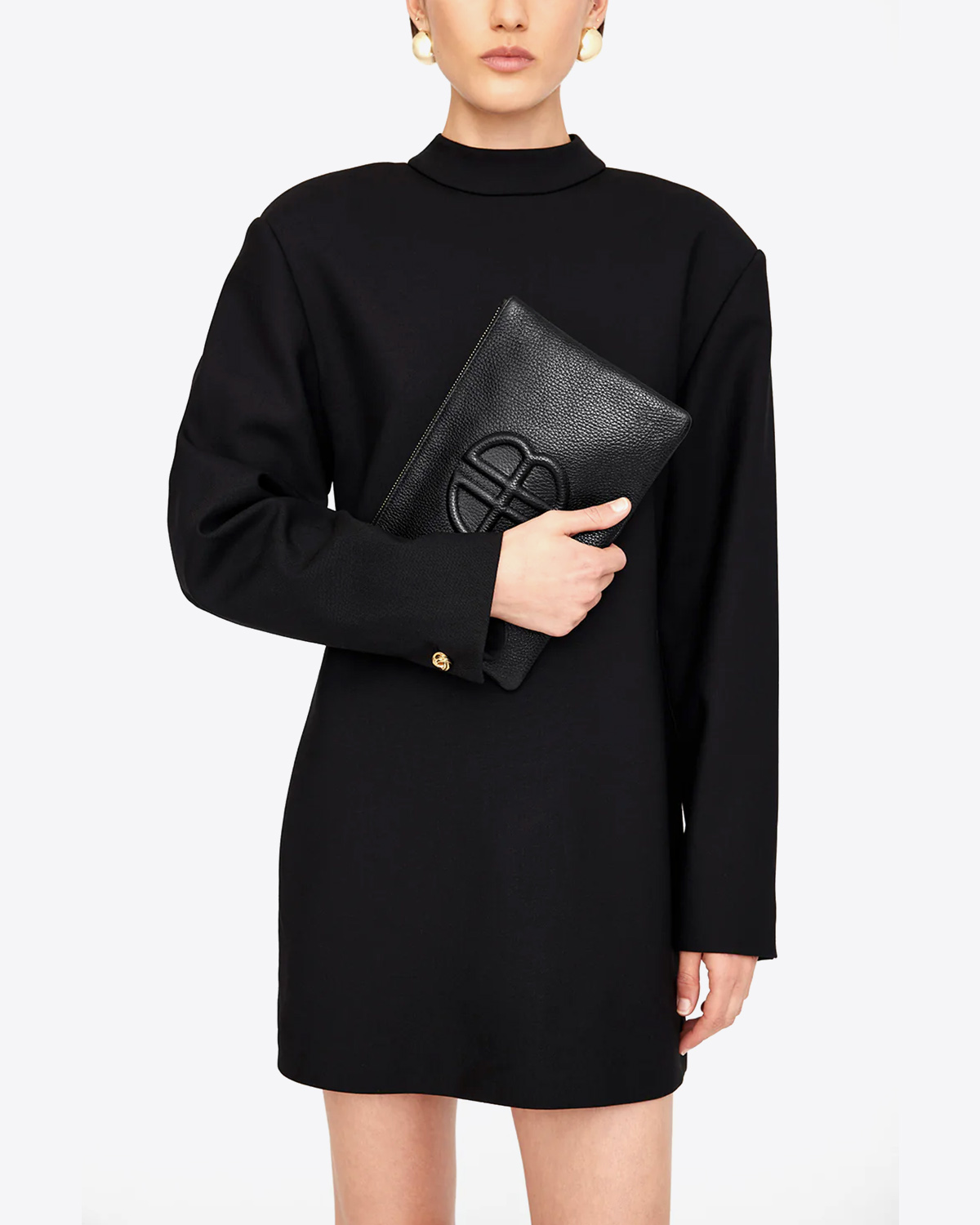 Pochette rectangulaire Lili en cuir noir Anine Bing. Portée à la main avec une robe noire. 