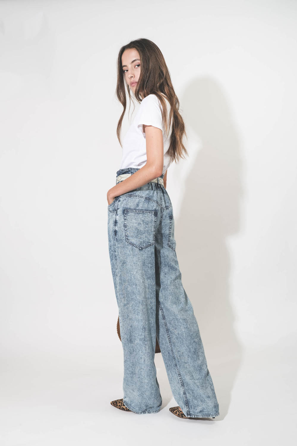 Pantalon taille haute en lyocell bleu délavé Priana Isabel Marant Etoile. Porté avec une ceinture en cuir blanc.