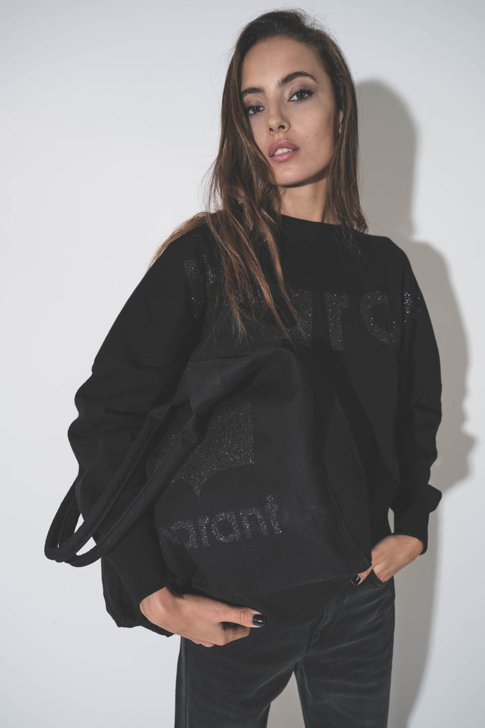 Sweatshirt manches chauve-souris noir logo MARANT à paillettes Houston Isabel Marant Etoile. Porté avec un sac en toile logo à paillettes assorti.