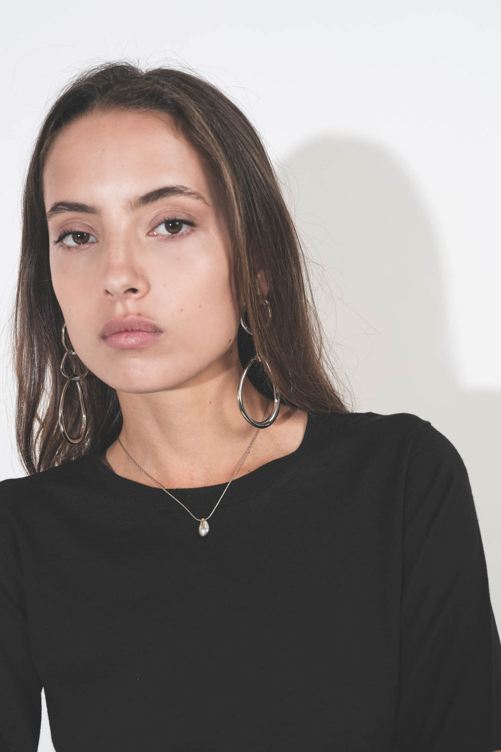 Collier ras du cou avec médaille perle en métal argenté sur chaine Shiny Day Isabel Marant. Porté sur un pull noir. 