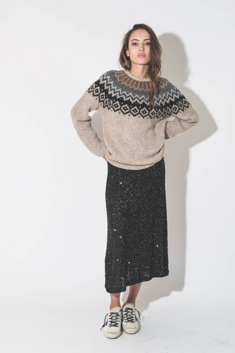 Jupe midi évasée à paillettes noires Mikuta. Porté avec un pull péruvien en alpaga beige.