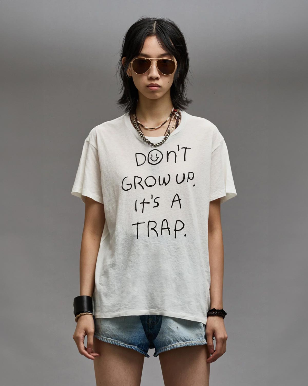 Tee-shirt manches courtes blanc à message "Don't Grow Up It's A Trap" R13. Porté de face.