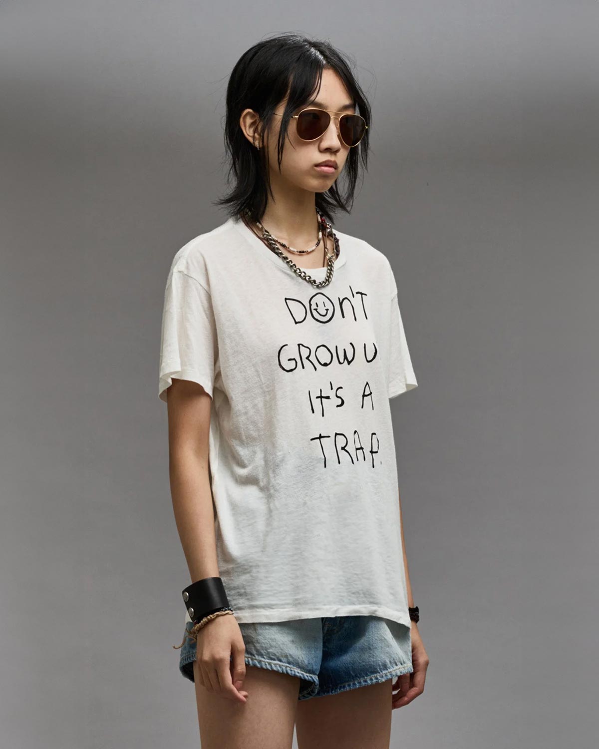 Tee-shirt manches courtes blanc à message "Don't Grow Up It's A Trap" R13. Porté de profil.